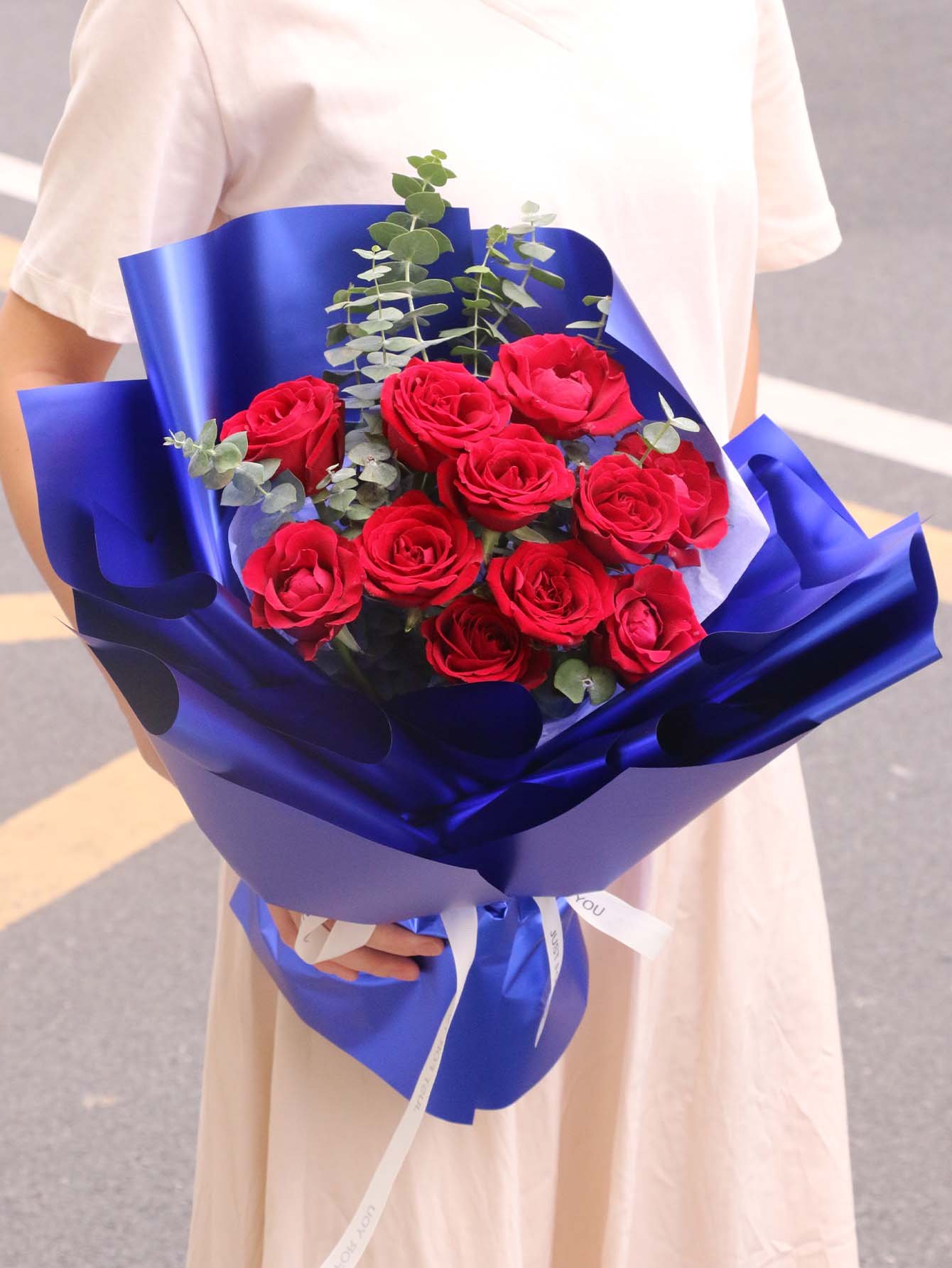 Red rose bouquet wrapped in blue flower wrapping paper